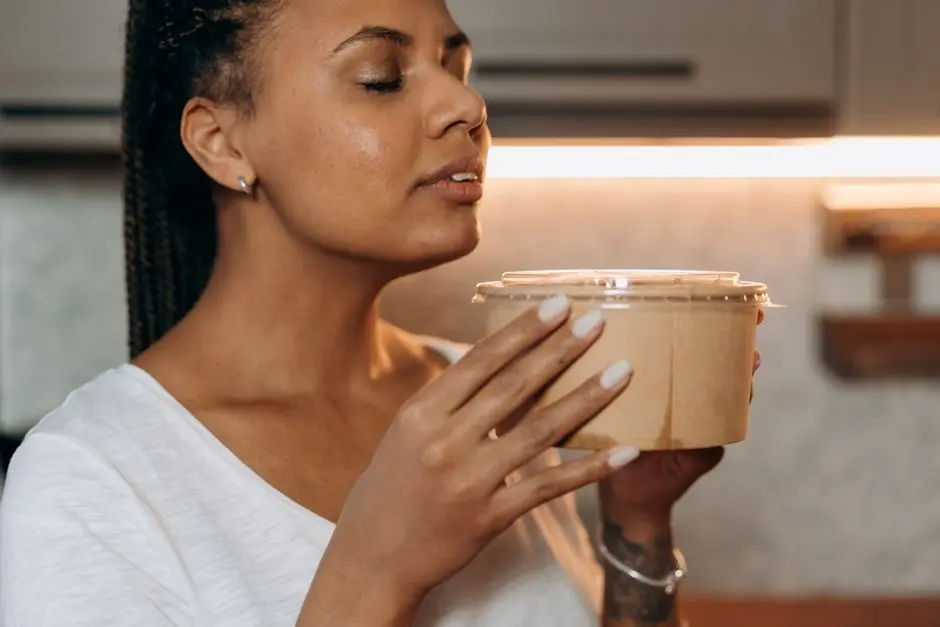 alt perempuan memegang wadah masker oatmeal di dapur sederhana